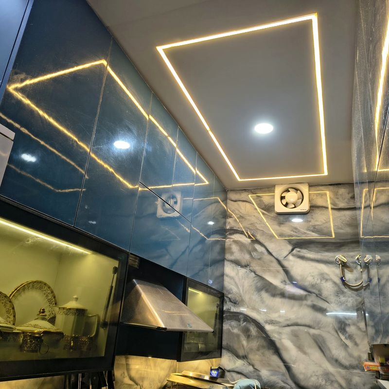 Navy gloss kitchen with marble-pattern backsplash.
