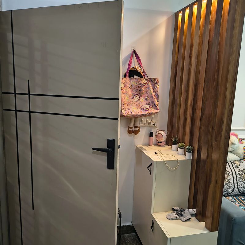 Grey grooved wardrobe beside a walnut slatted entry screen.